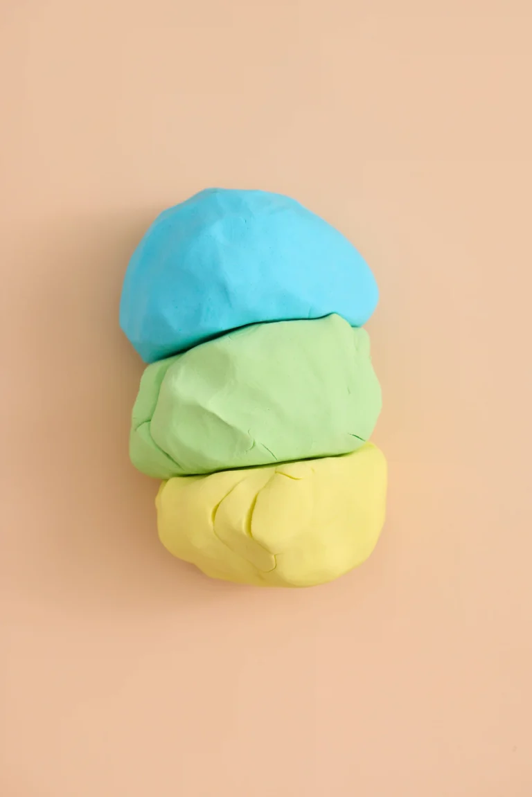 cloud dough in blue yellow and green on a peach background