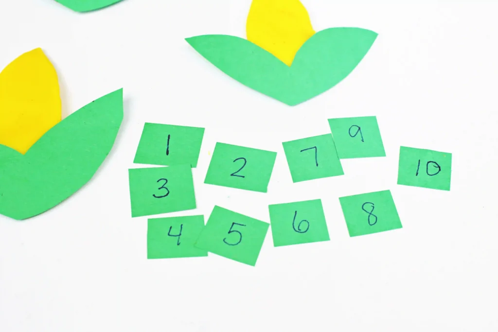 green construction paper cut into squares with numbers 1-10 on them