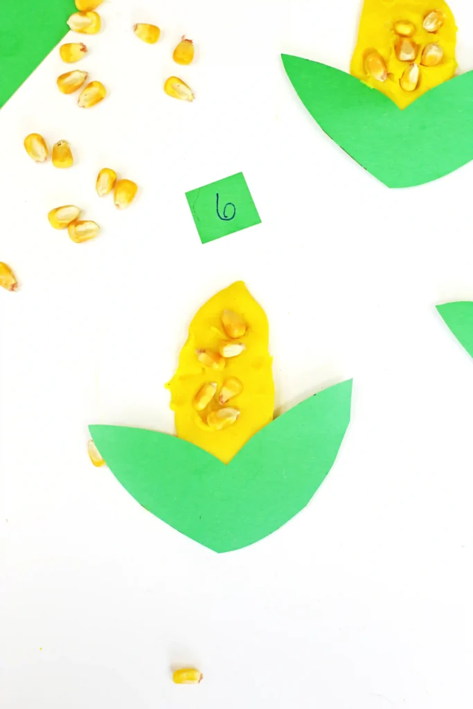 a fall counting activity for preschoolers that has corn kernels in playdough that looks like corn