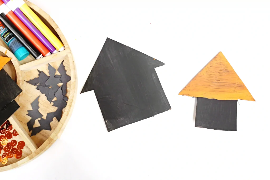 cardboard cut to look like houses and painted black and orange for this Halloween activity