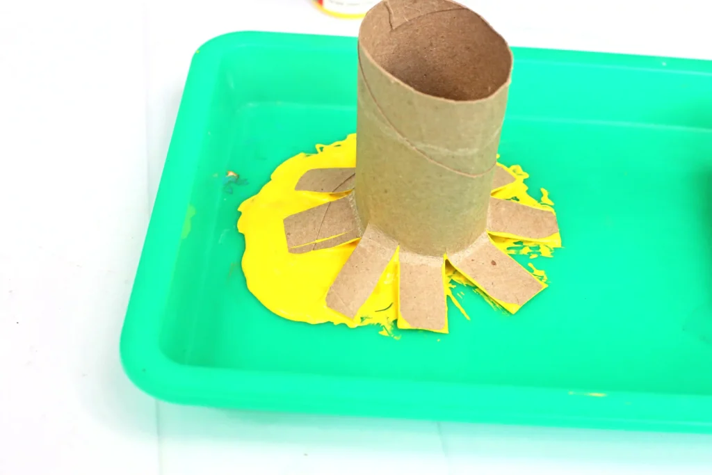 a toilet paper roll that is cut on the ends dipped in yellow paint