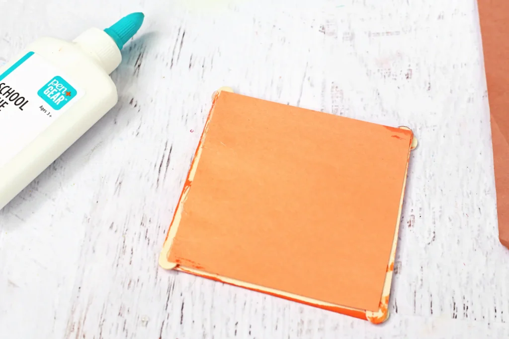 an orange piece of construction paper glued to a popsicle stick frame
