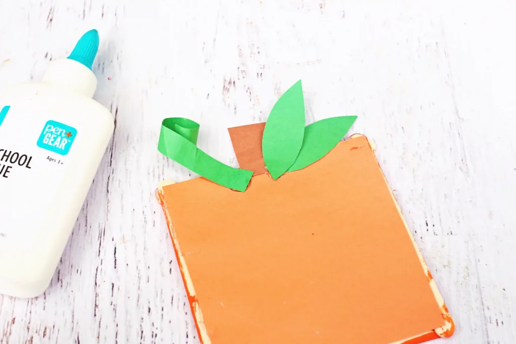 construction paper stem and leaves glued onto a square popsicle stick frame with construction paper inside