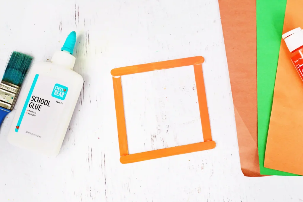 four orange painted popsicle sticks glued into a square
