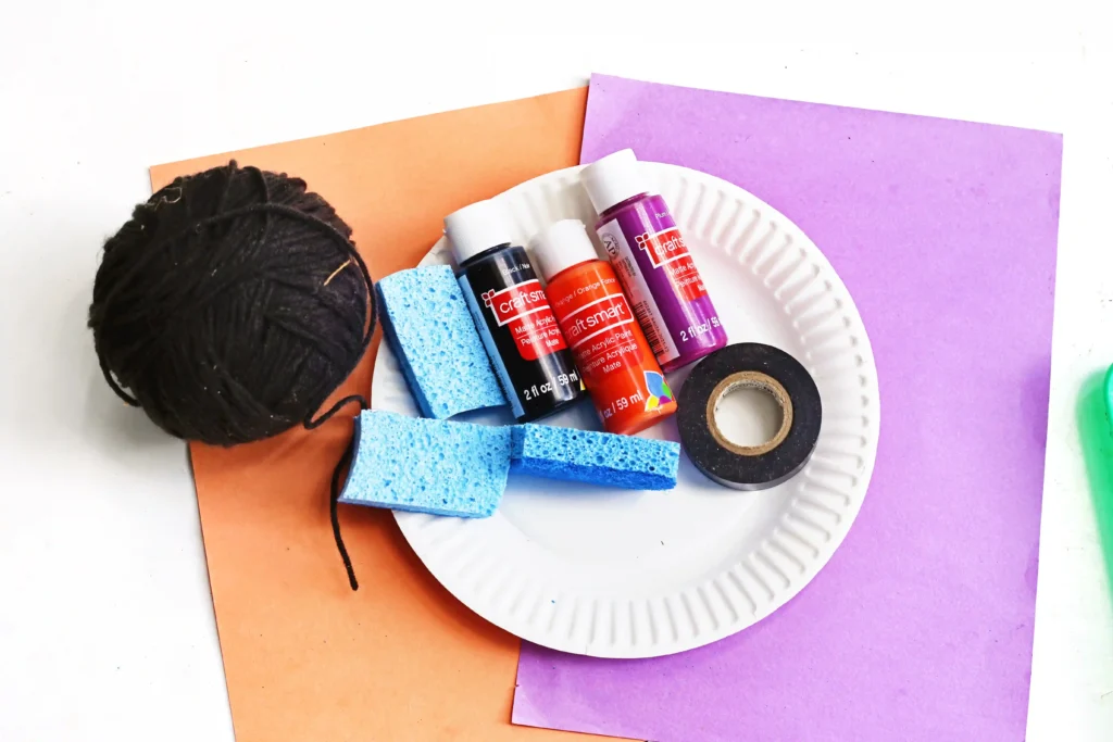 supplies for the spider web painting - paint, paper plate, string, and sponges