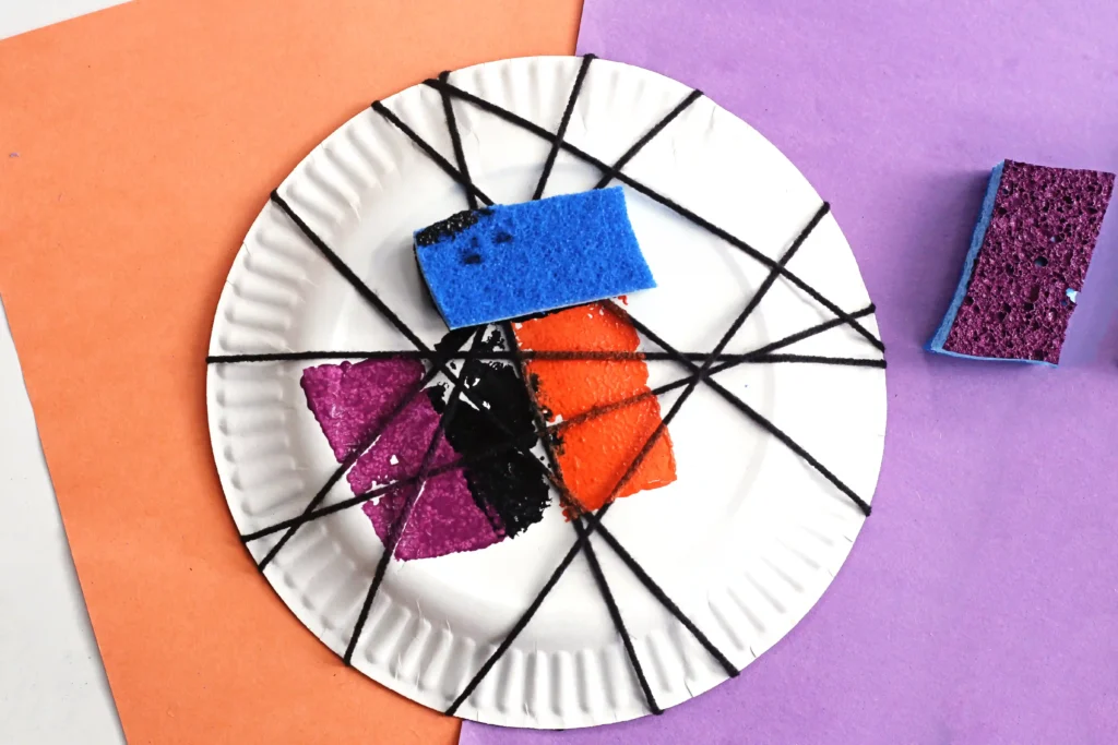 a sponge with paint on a paper plate thats wrapped with black string