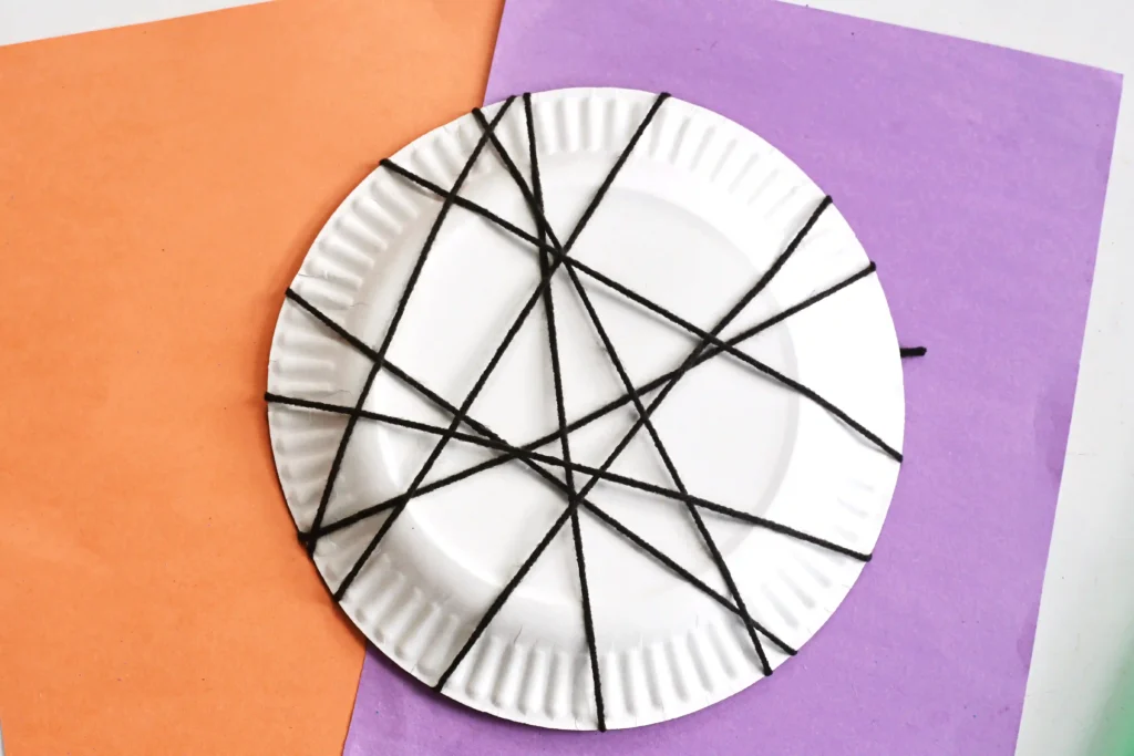 black yarn wrapped around a paper plate