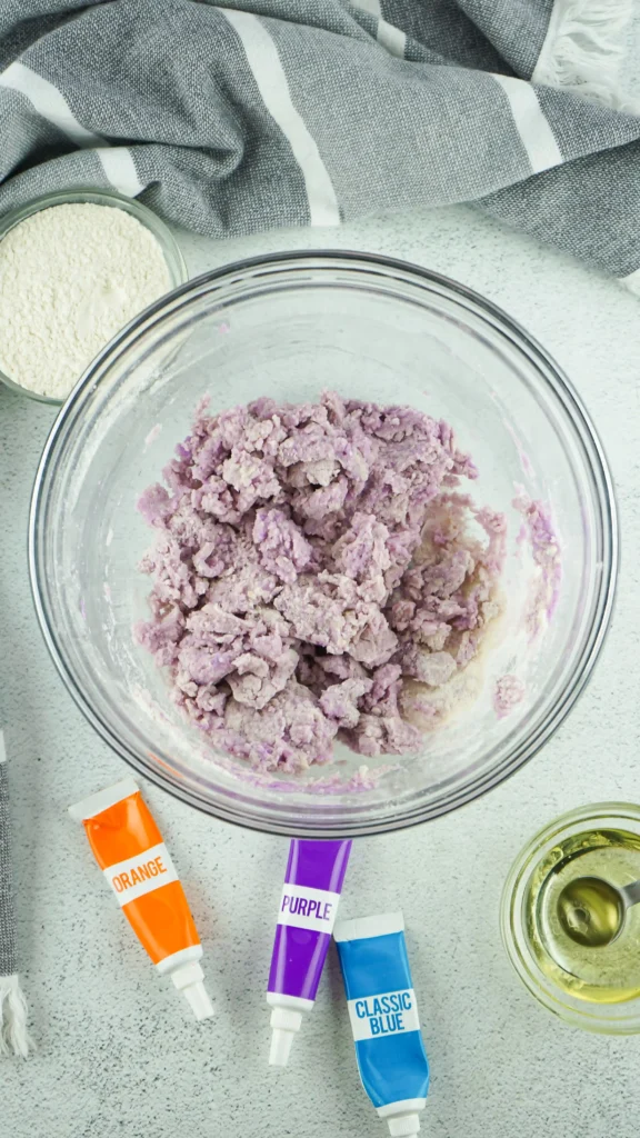 a glass bowl with purple playdough