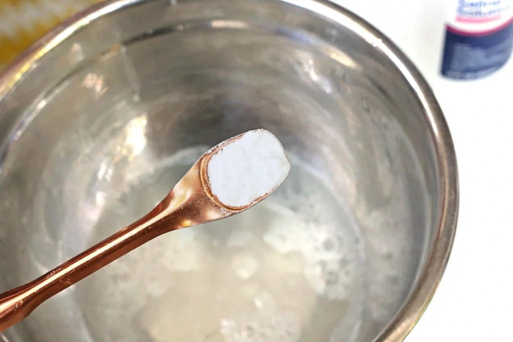 baking soda being added to a bowl of glue and water for these slime recipes