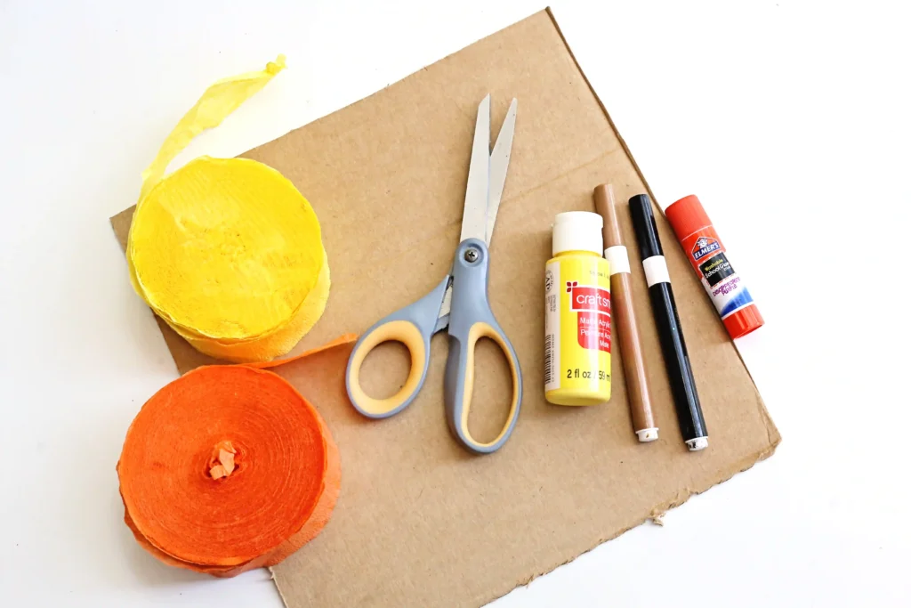 supplies for this cardboard sunflower craft - cardboard, yellow and orange streamers, yellow paint, a black and brown marker, scissors, and glue