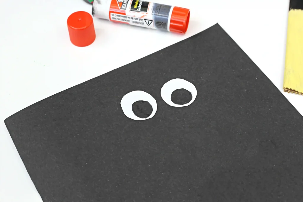 paper eyes glued on to a paper bag painted black