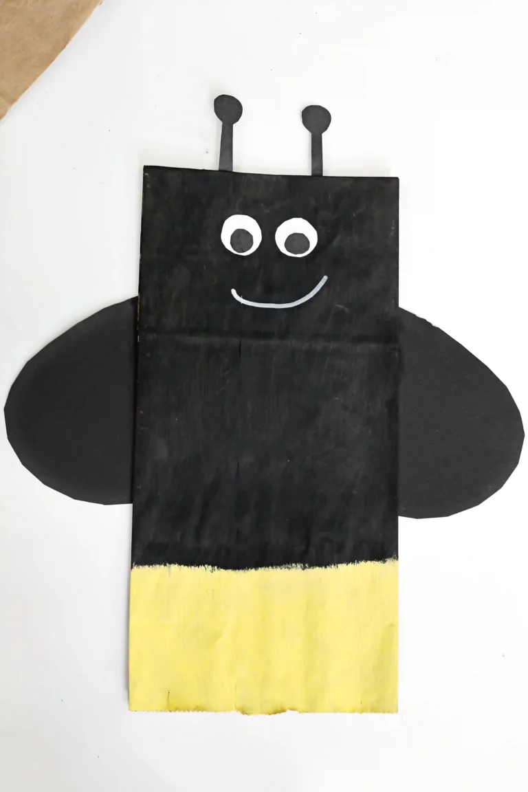 a Firefly Paper Bag Craft of a paper plag painted black and yellow and decorated to look like a firefly