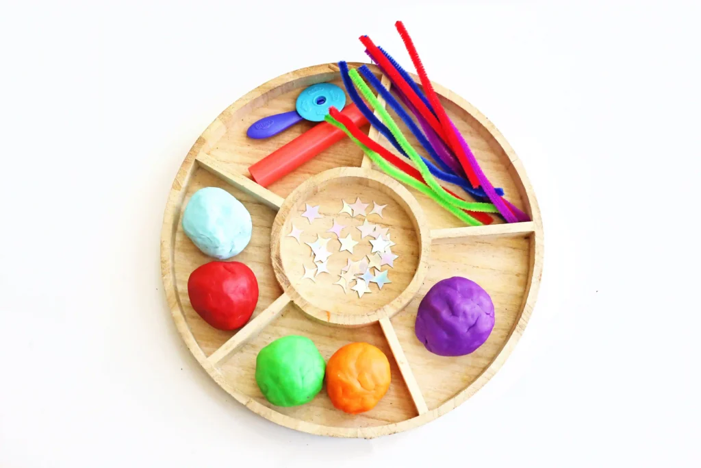 supplies for the firework activity: playdough, foam stars, pipe cleaners and playdough tools