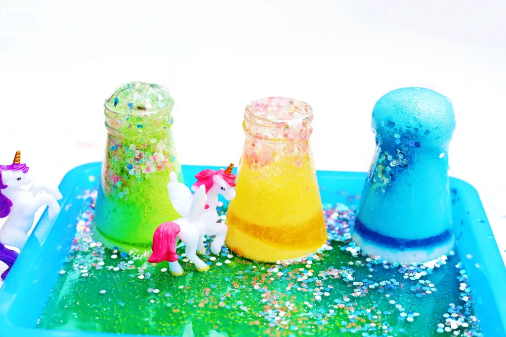 fizzy unicorn potions with glitter on a blue tray