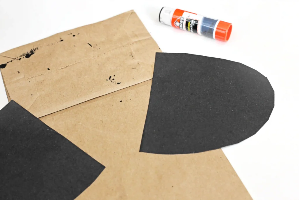 black construction paper wings glued onto the back of a brown paper bag