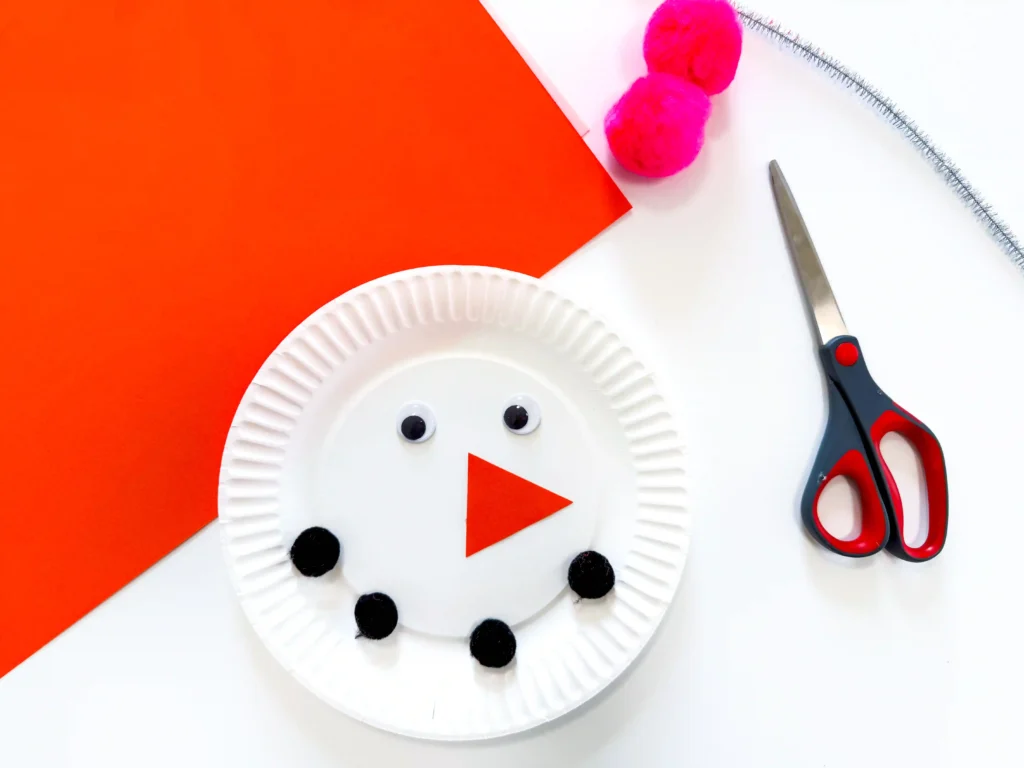 a paper plate decorated to look like a snowman