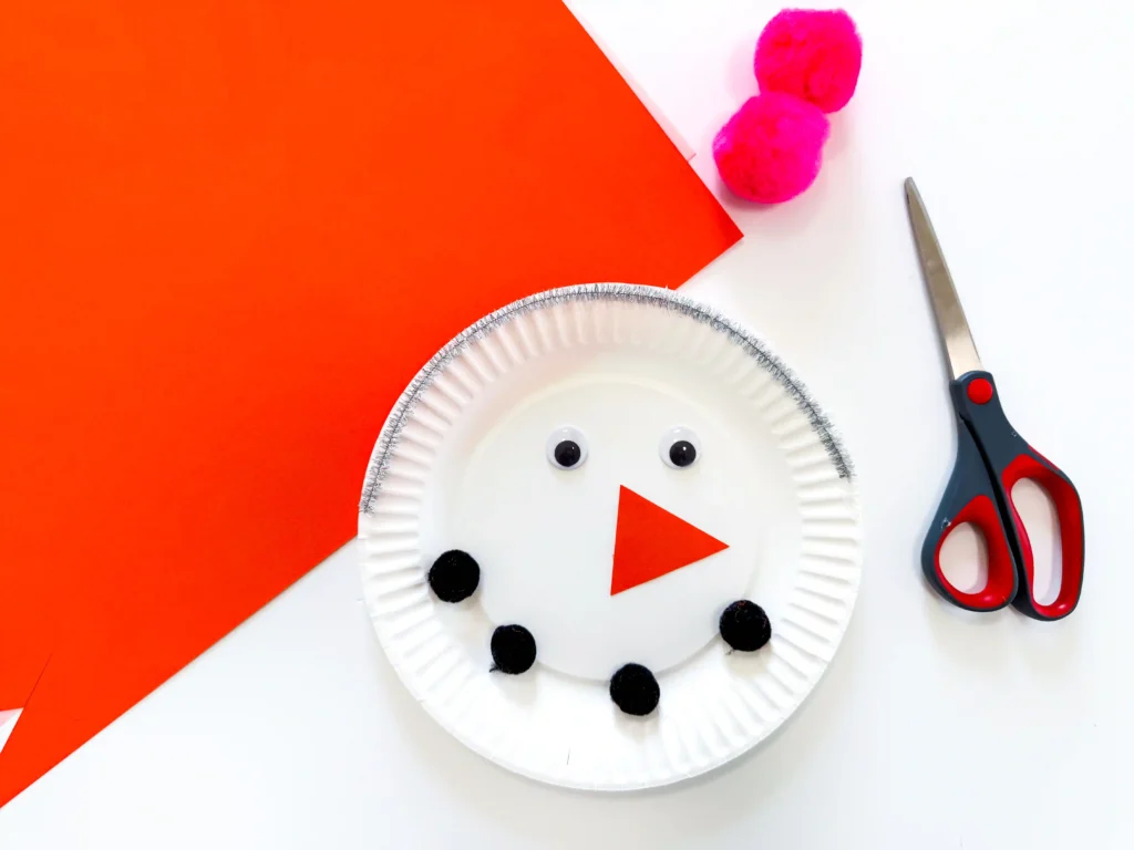 a paper plate decorated to look like a snowman
