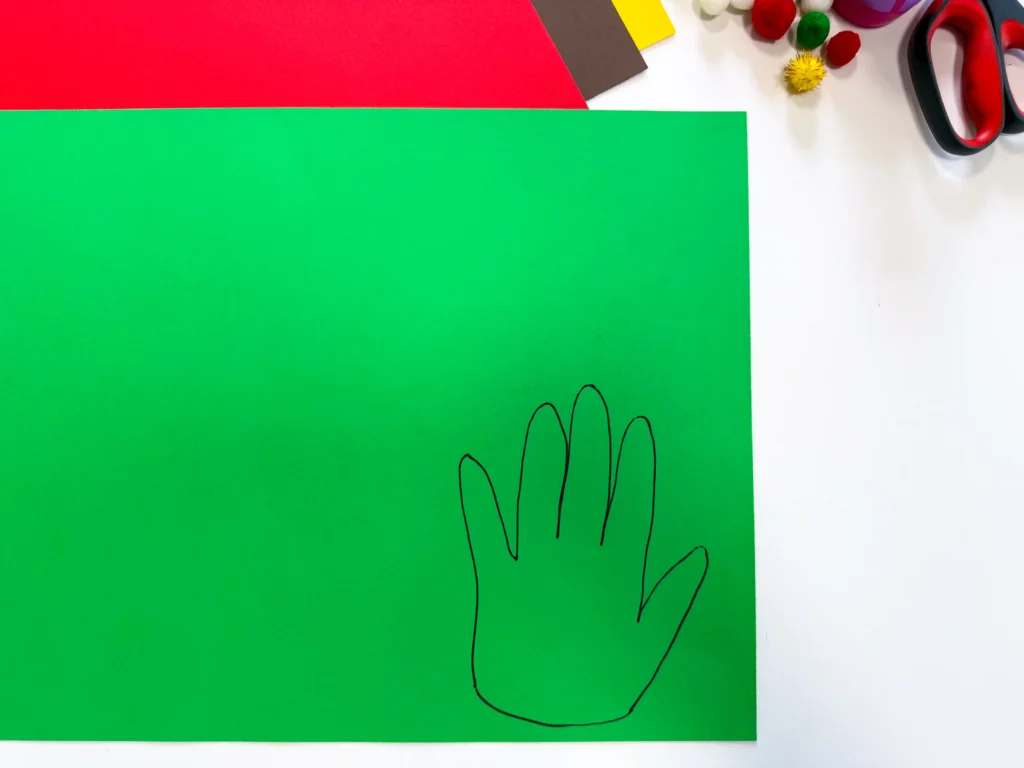 green construction paper with a hand traced on it