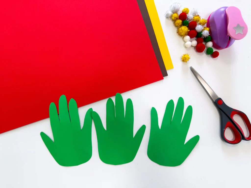 3 handprints cut out of green paper