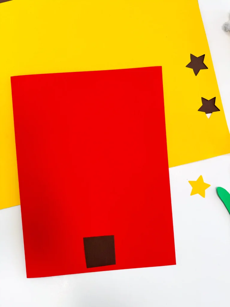 red construction paper with a brown square on it