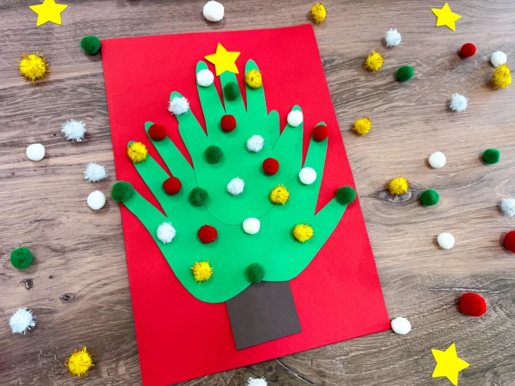 a christmas card of 3 handprints that make a christmas tree with pom poms glued on