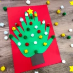 a christmas card of 3 handprints that make a christmas tree with pom poms glued on