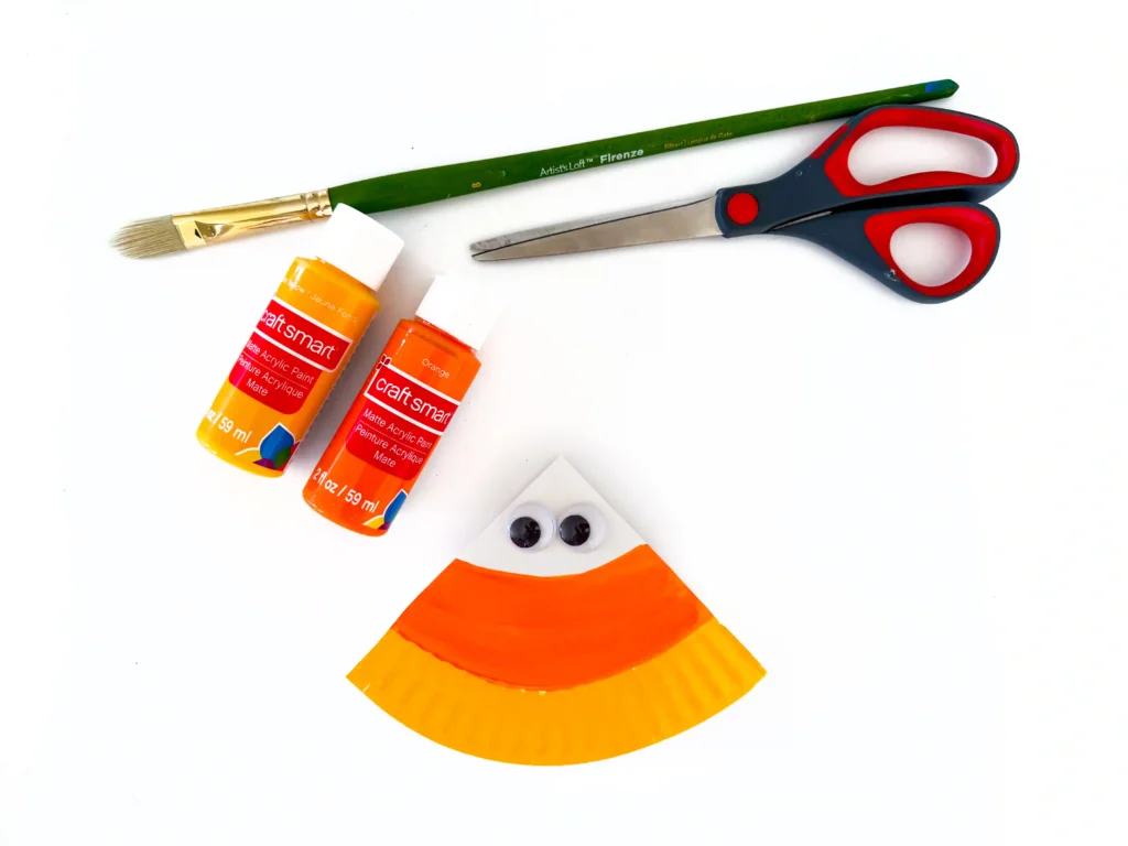 a paper plate cut into a triangle and painted to look like candy corn with googly eyes