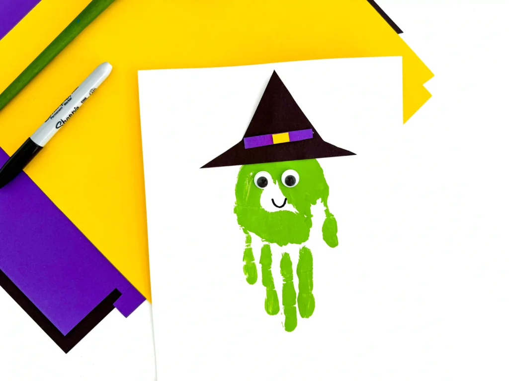 a green handprint decorated to look like a witch