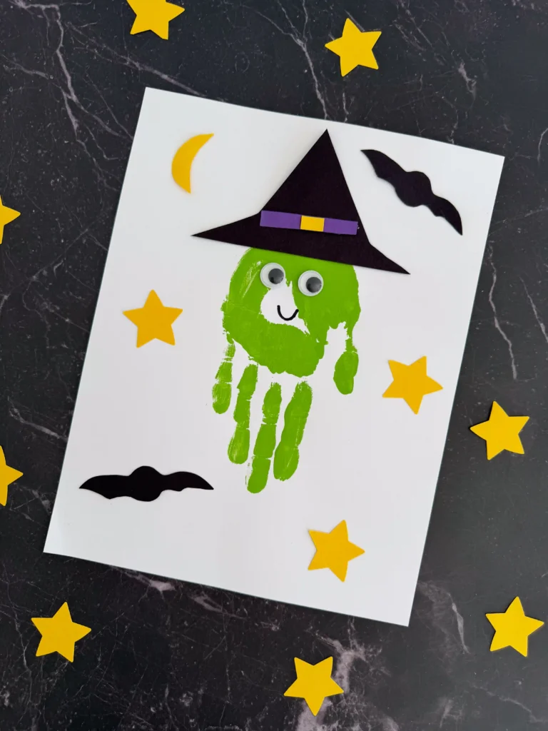 a Handprint Witch Craft of a green handprint decorated to look like a witch