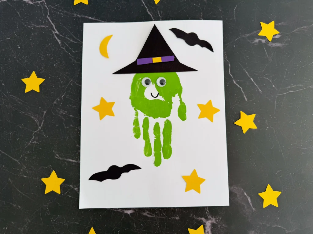 a Handprint Witch Craft of a green handprint decorated to look like a witch
