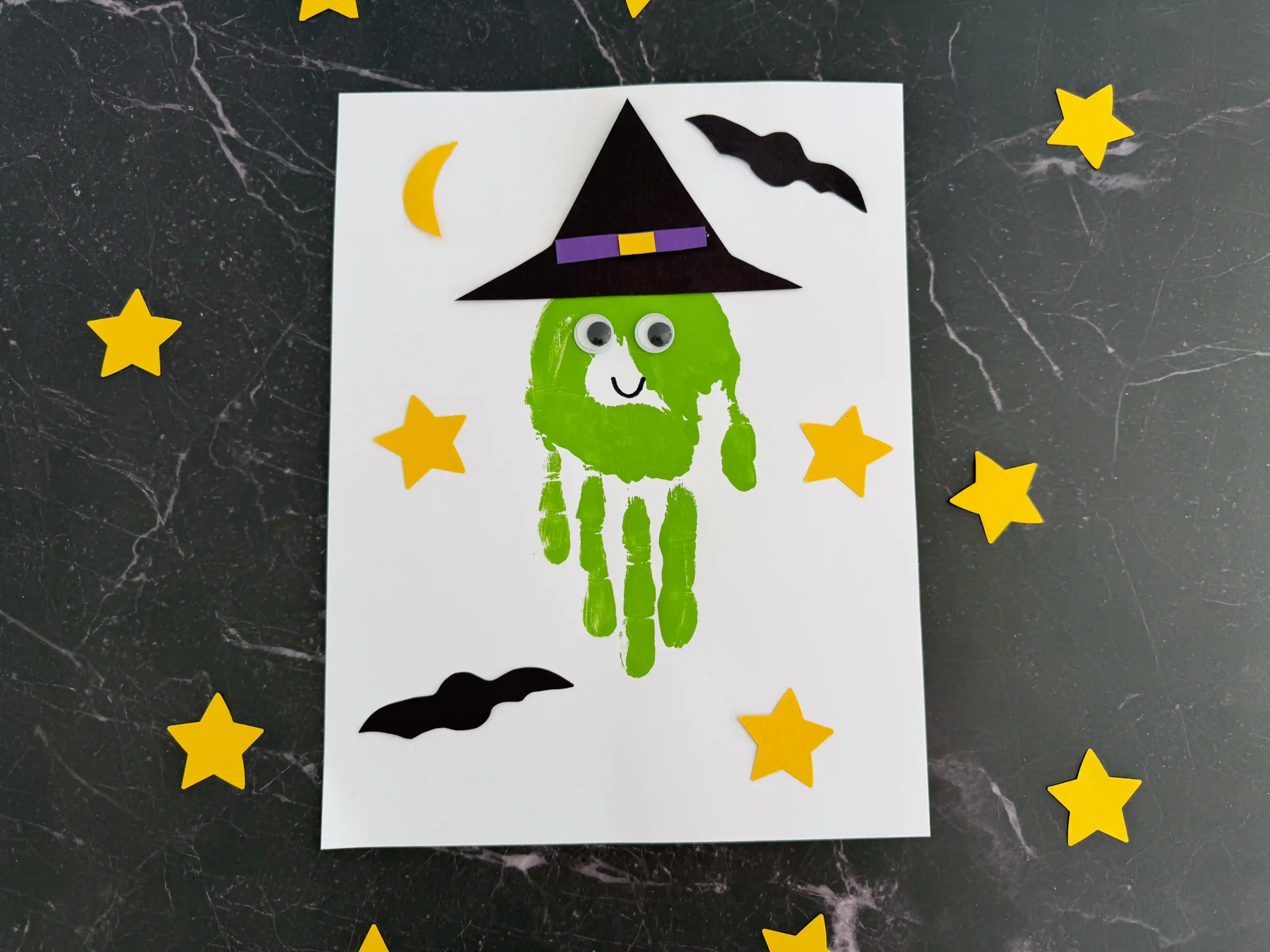 a Handprint Witch Craft of a green handprint decorated to look like a witch