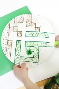 a paper plate with a maze drawn on it next to a magnet