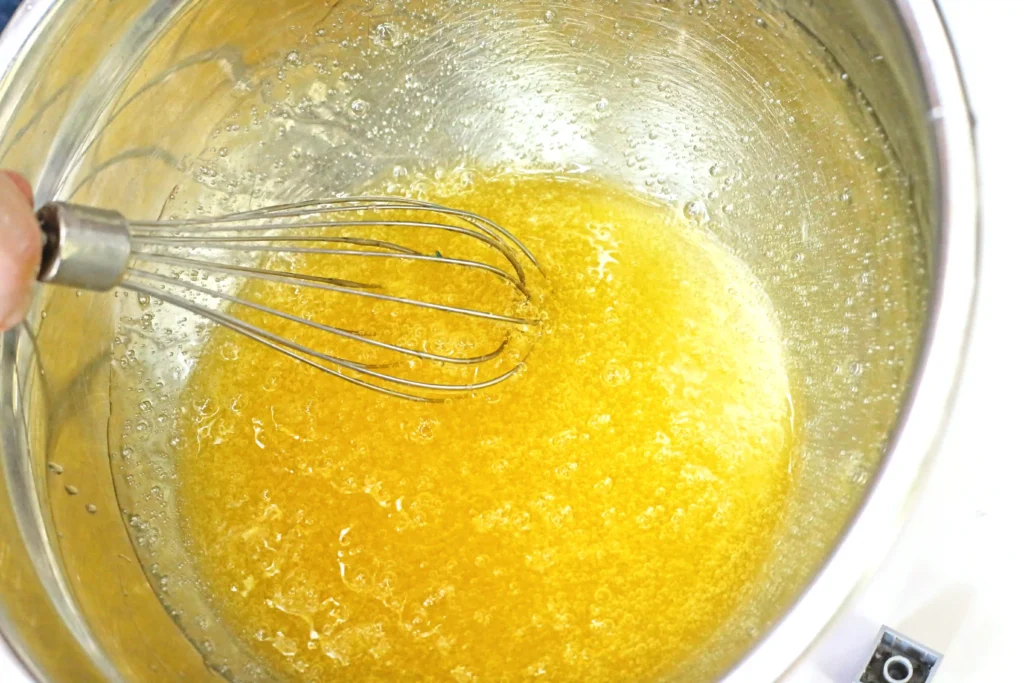 yellow slime mixture in a bowl with a whisk for these sensory activities for preschoolers