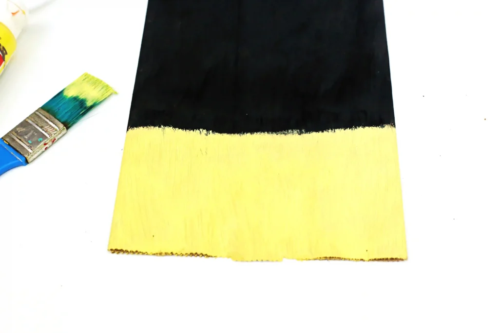 a paper bag painted 3/4 black and the rest yellow
