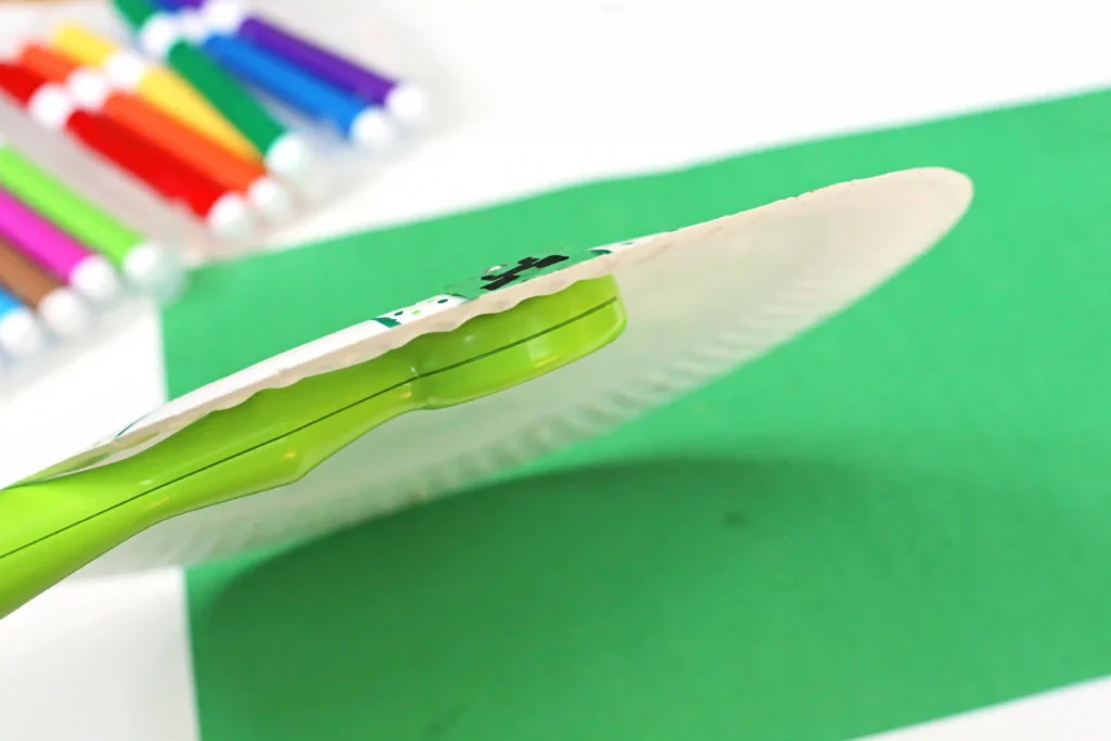 a paper plate with a magnetic wand on one side and a paper clip on another