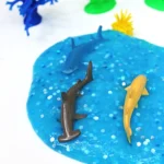blue slime with glitter and toy sharks