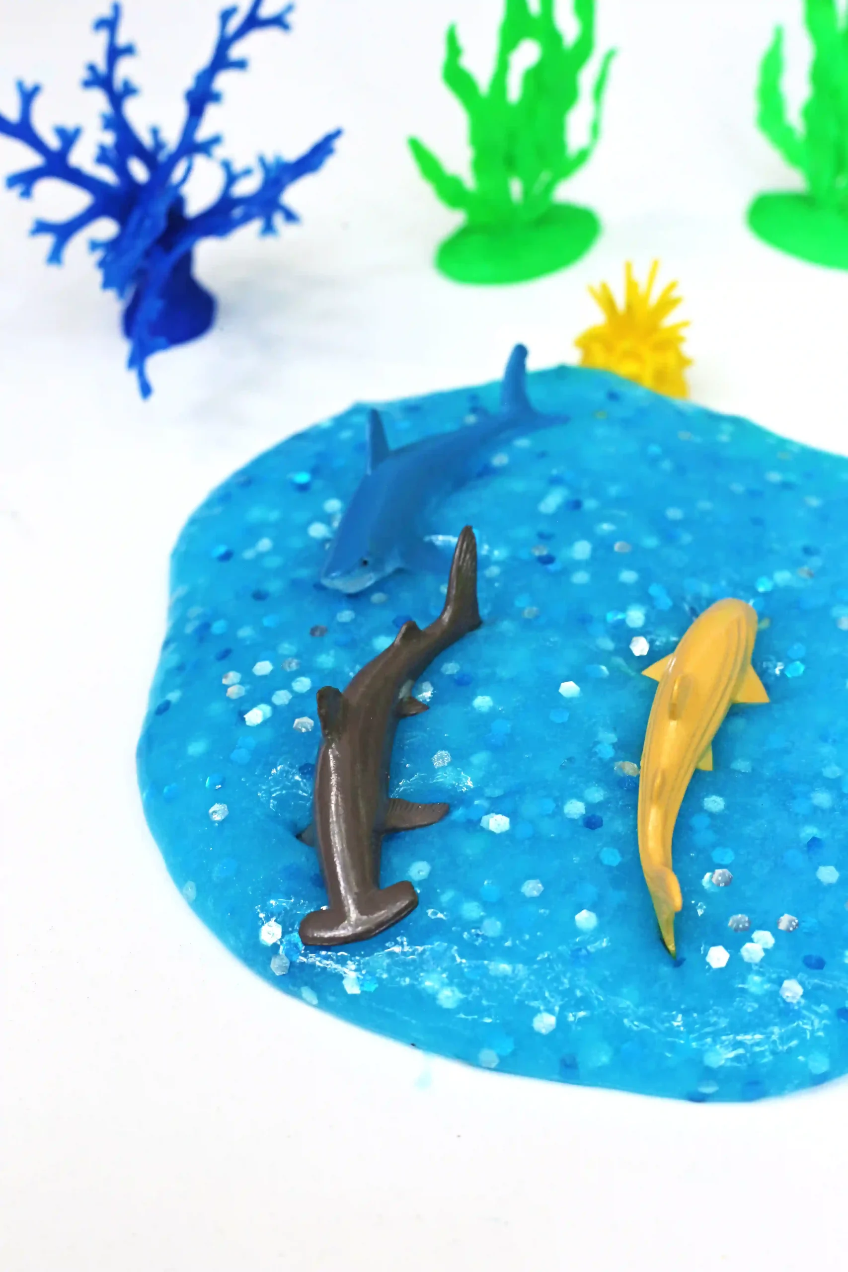 blue slime with glitter and toy sharks