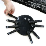 a Spider Number Matching Activity that has a kid placing a black clothespin with a number on the spider with the same number