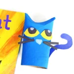a toilet paper roll painted and decorated to look like pete the cat