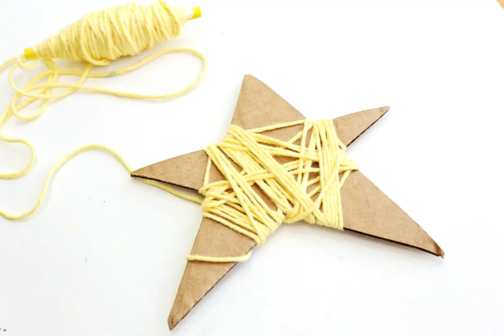 a Yarn-Wrapped Shooting Star Craft that is cardboard cut into a star and wrapped with yellow yarn