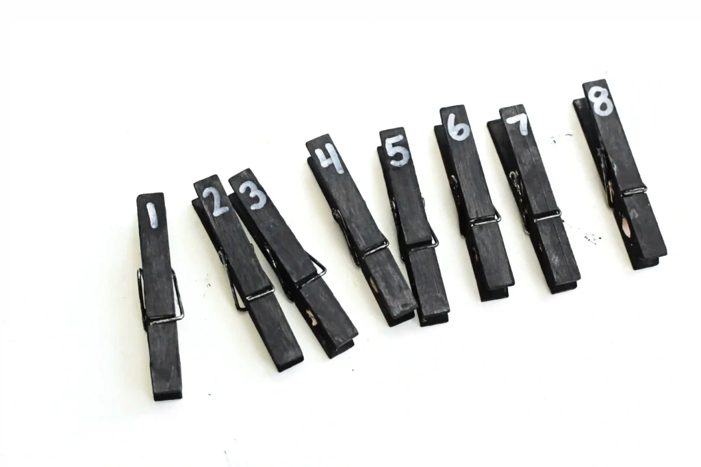 black clothespins with numbers 1-8 written on them