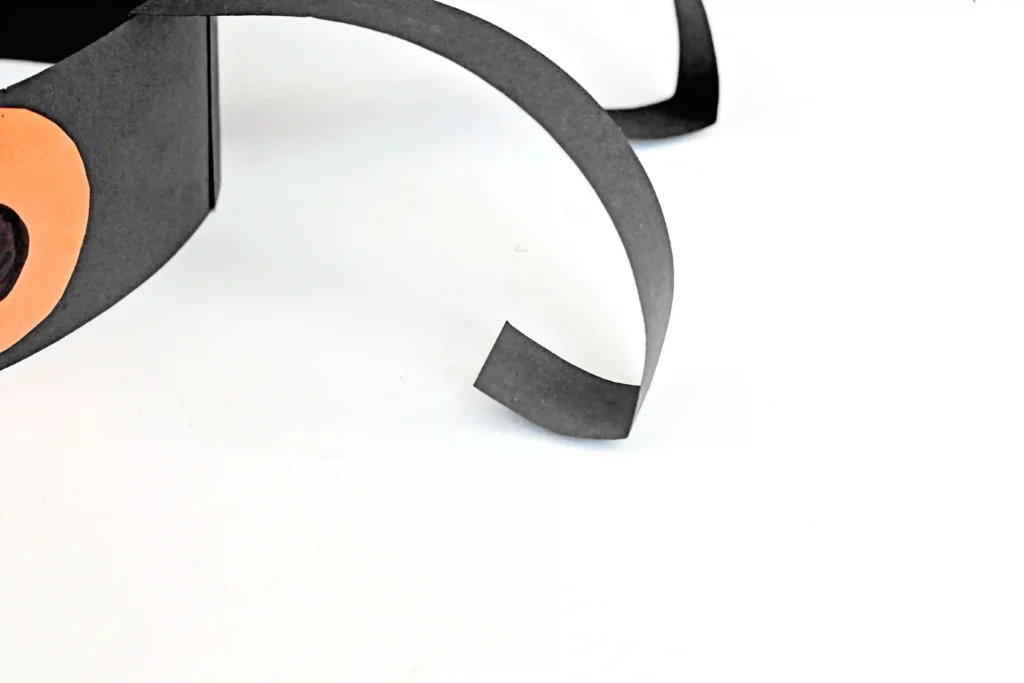 strips of black construction paper bent at the ends