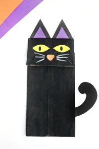 a paper bag painted black and decorated to look like a cat