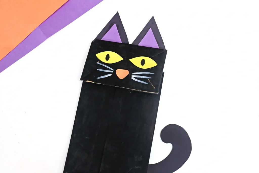 a paper bag painted black and decorated to look like a cat
