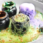 cauldrons with baking soda, vinegar, food coloring, and glitter to make halloween volcanoes