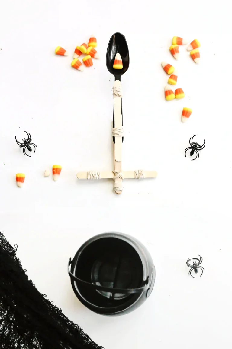 a catapult made out of popsicle sticks and a spoon surrounded by candy corn