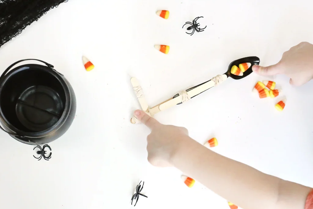 a kid using a catapult made out of a spoon to fling candy corn