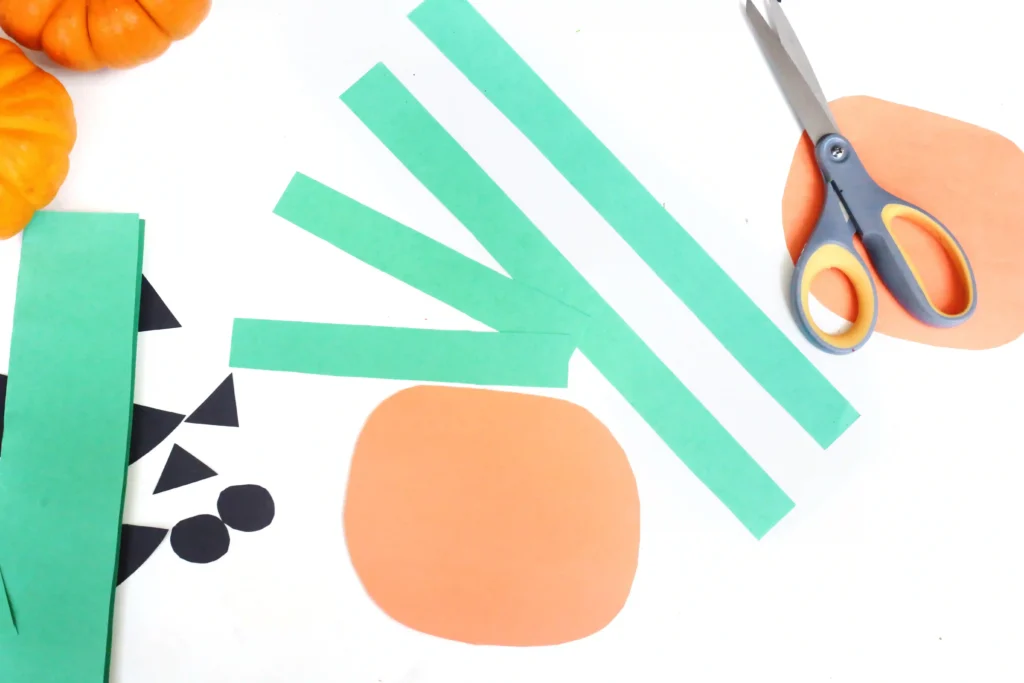 orange circle and green strips cut out of construction paper