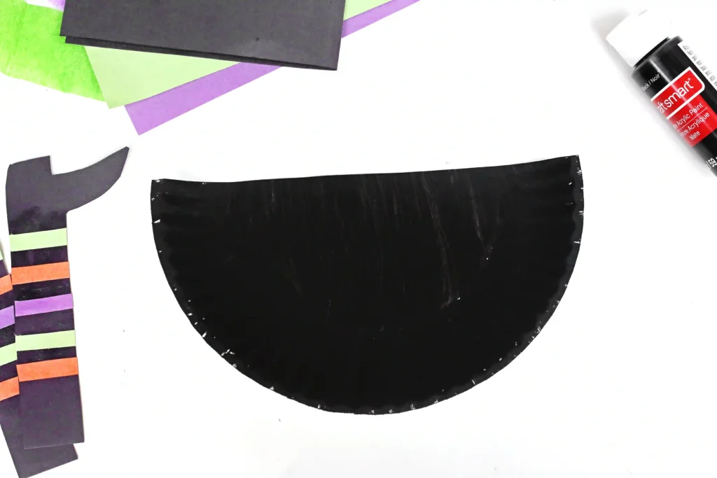 a paper plate cut in half and painted black