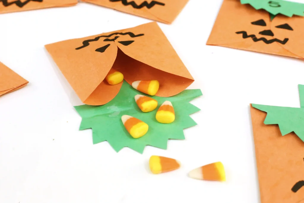 construction paper jack-o-lantern bags with treats inside